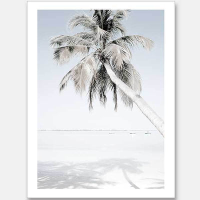 The "Beach Please Unframed Art Print" by Urban Road features a tall palm tree leaning over a sandy beach with calm blue water, capturing a minimalistic and serene coastal scene with the palm's shadow gently cast on the sand.