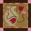 Abstract floral composition with red blooms on black curving stems over a camel and brown patchwork base, framed in soft pink, from the Shatha collection with Urban Road.