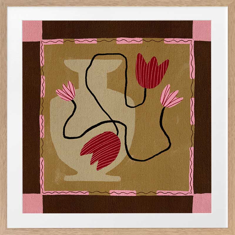 Abstract floral composition with red blooms on black curving stems over a camel and brown patchwork base, framed in soft pink, from the Shatha collection with Urban Road.