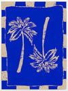 Vibrant coastal-inspired artwork featuring two cream palm trees with sweeping fronds on a bold cobalt blue background with a striped border, from the Shatha collection with Urban Road.