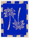 Vibrant coastal-inspired artwork featuring two cream palm trees with sweeping fronds on a bold cobalt blue background with a striped border, from the Shatha collection with Urban Road.