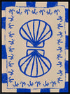 Symmetrical blue shell motif with palm-like flourishes, framed by a blue and cream checkered border on a neutral base, from the Shatha collection with Urban Road.