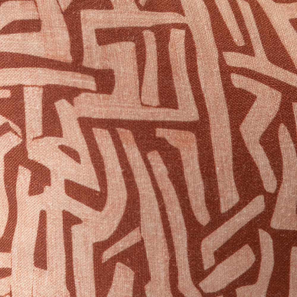 Cushion from the Tim Neve collection by Urban Road, with an intricate terracotta maze pattern on a warm brown background.