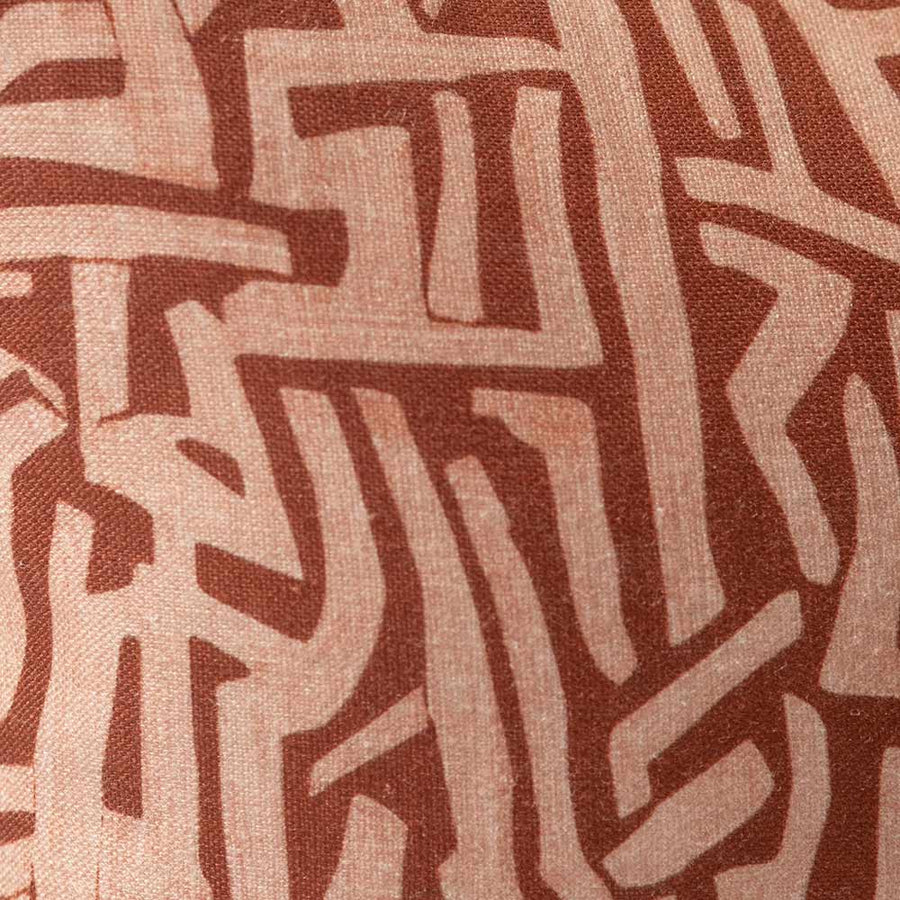 Cushion from the Tim Neve collection by Urban Road, with an intricate terracotta maze pattern on a warm brown background.
