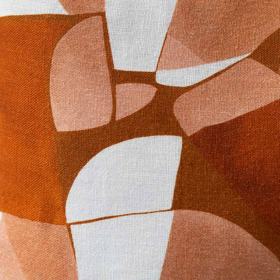 Cushion from the Tim Neve collection by Urban Road, featuring a golden patchwork design with organic curved shapes in neutral hues.