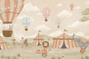 Pastel circus fair with hot air balloons, striped tents and playful animal performers, from the Little Tails Collection by Urban Road.