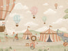 Pastel circus fair with hot air balloons, striped tents and playful animal performers, from the Little Tails Collection by Urban Road.